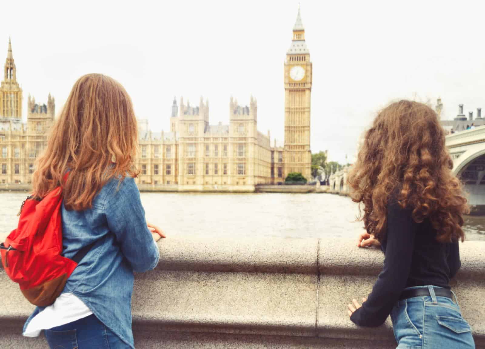 Two girls looking at big ben and houses of parliament in London