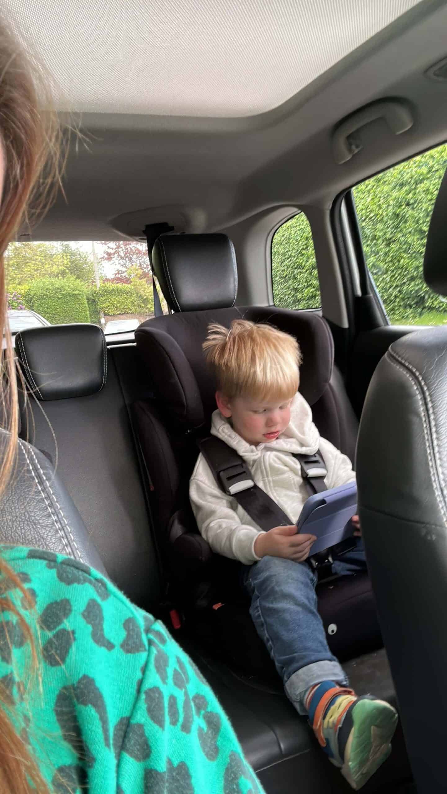 Toddler sat in car seat in back of car