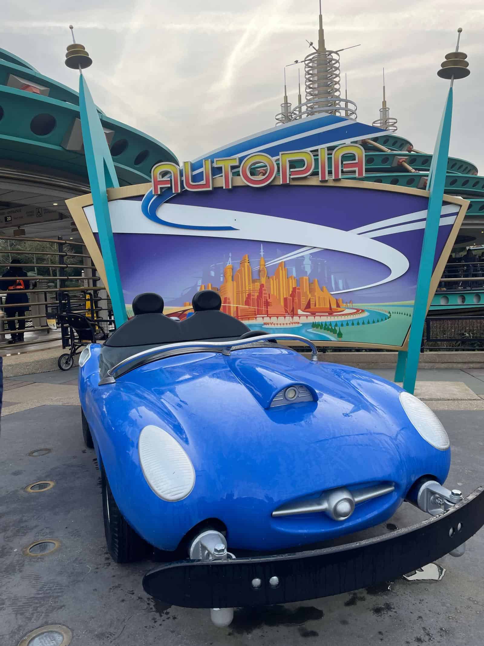Car from the Autopia ride at Disneyland Paris in front of the sign for the ride