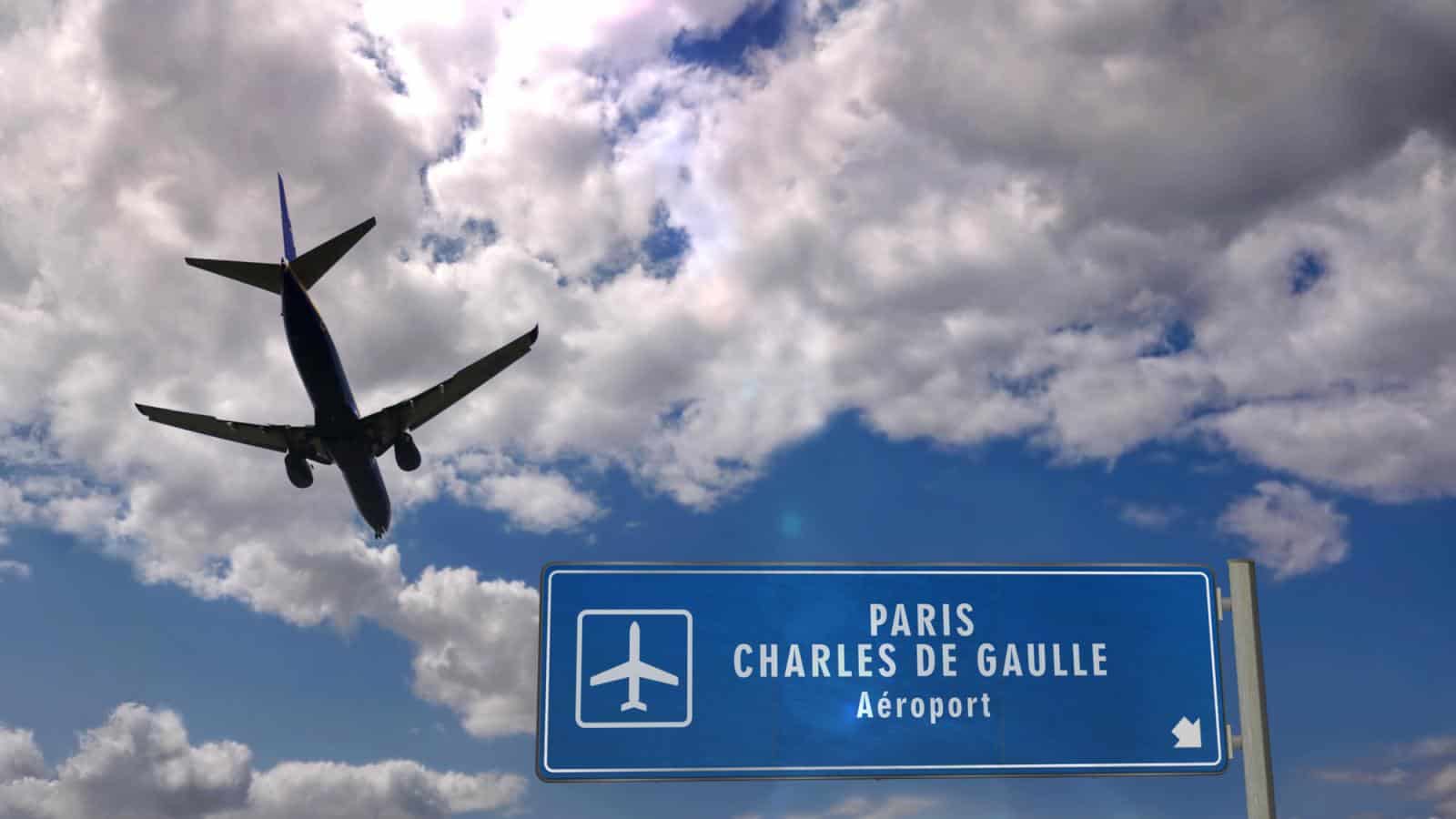 Sign for Paris Charles de Gaulle Airport with plane flying overhead